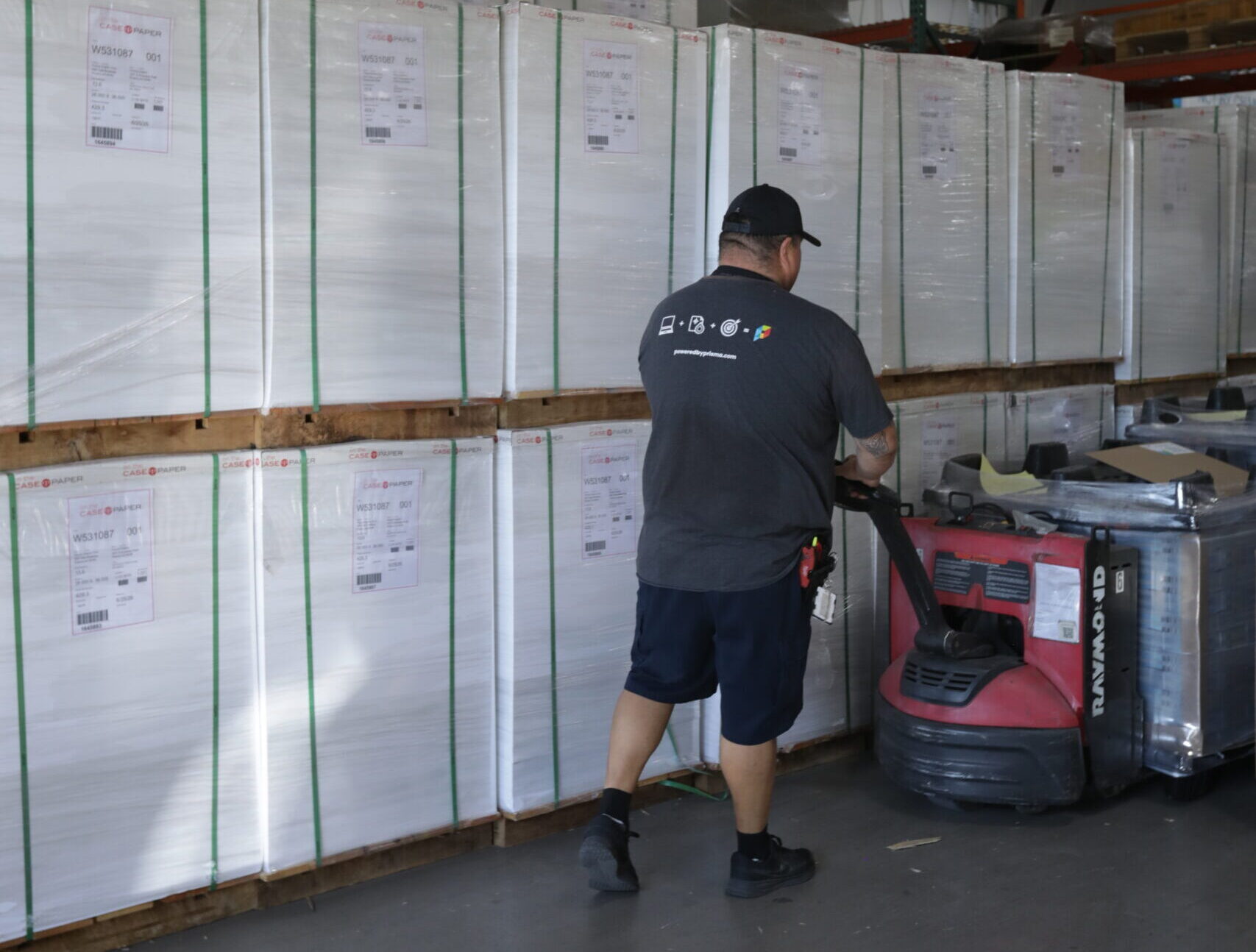 male worker moving skids of paper