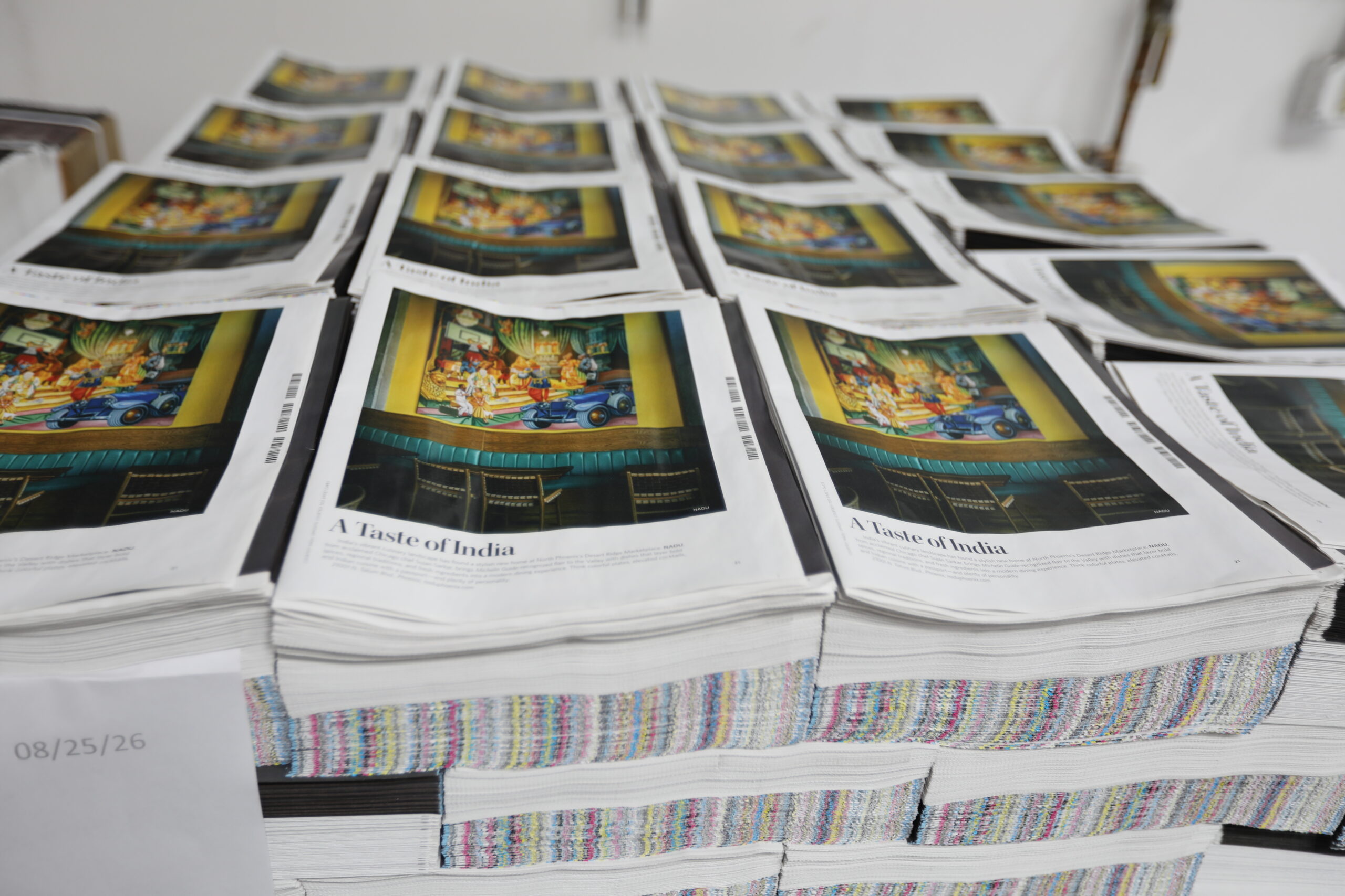 Stacks of freshly printed newspaper spreads featuring the "A Taste of India" feature story.