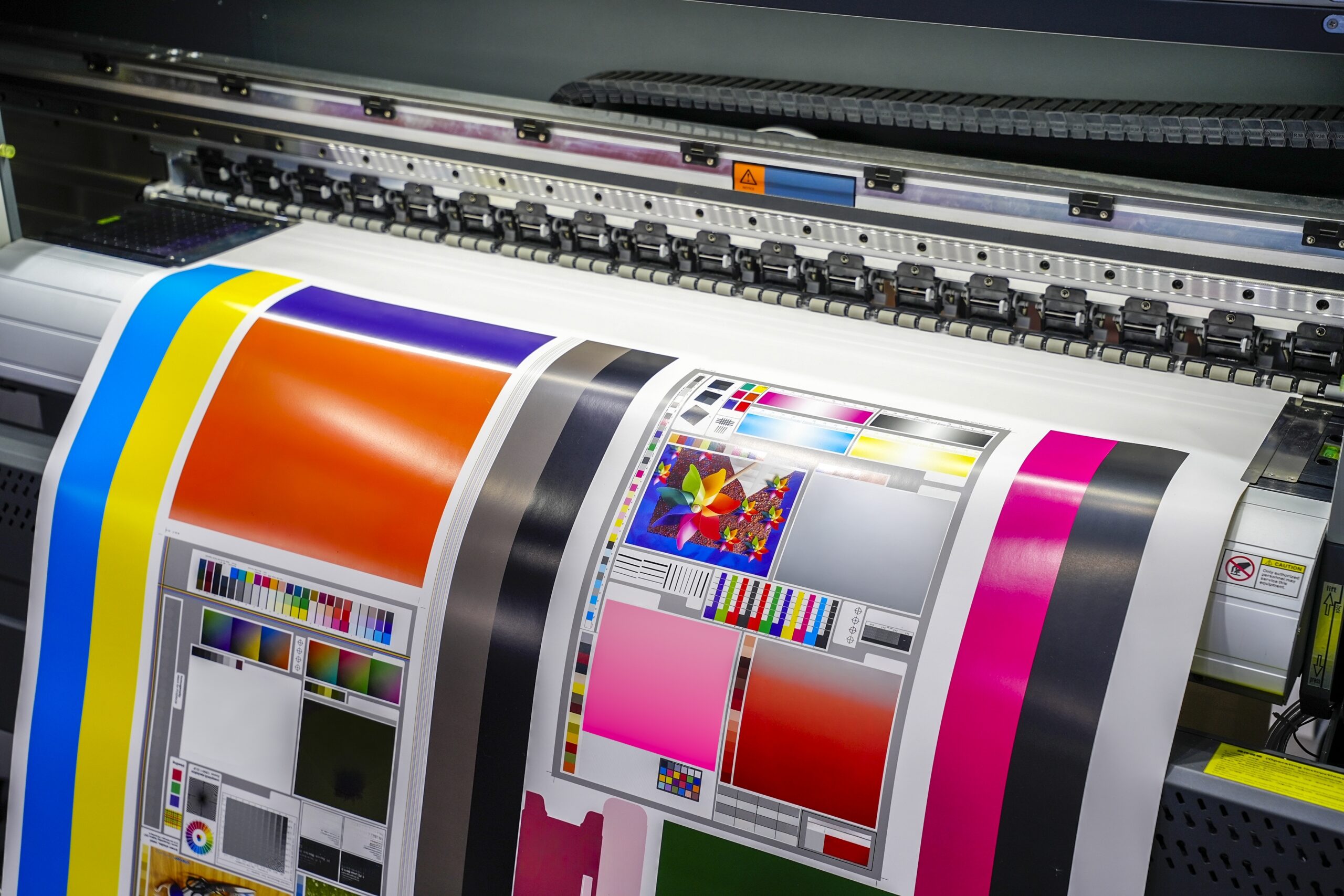 Wide-format printer producing a color calibration proof and test sheet.