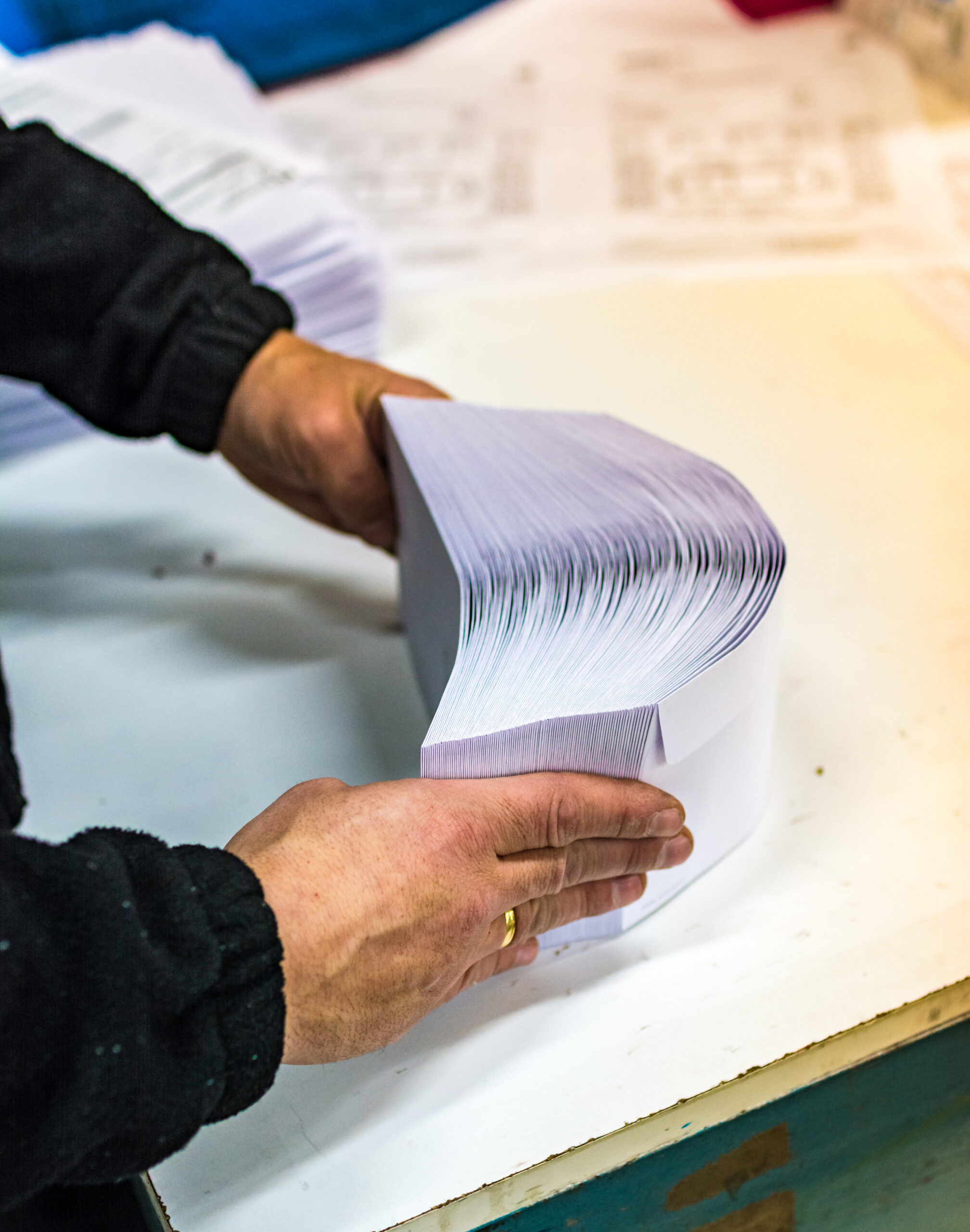 person manipulating envelopes for mailing