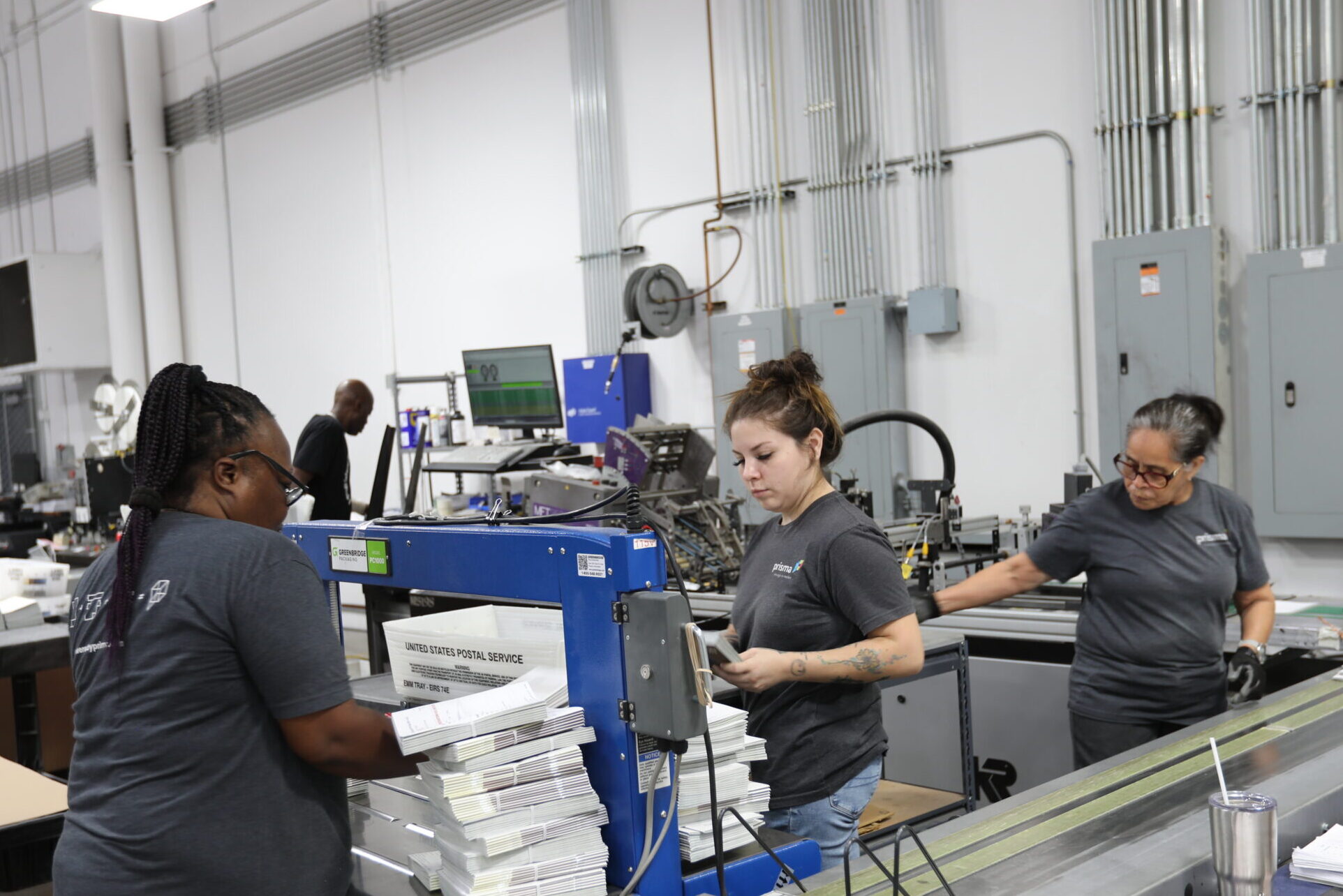 Prisma team members preparing and sorting bundled mail on the production floor.
