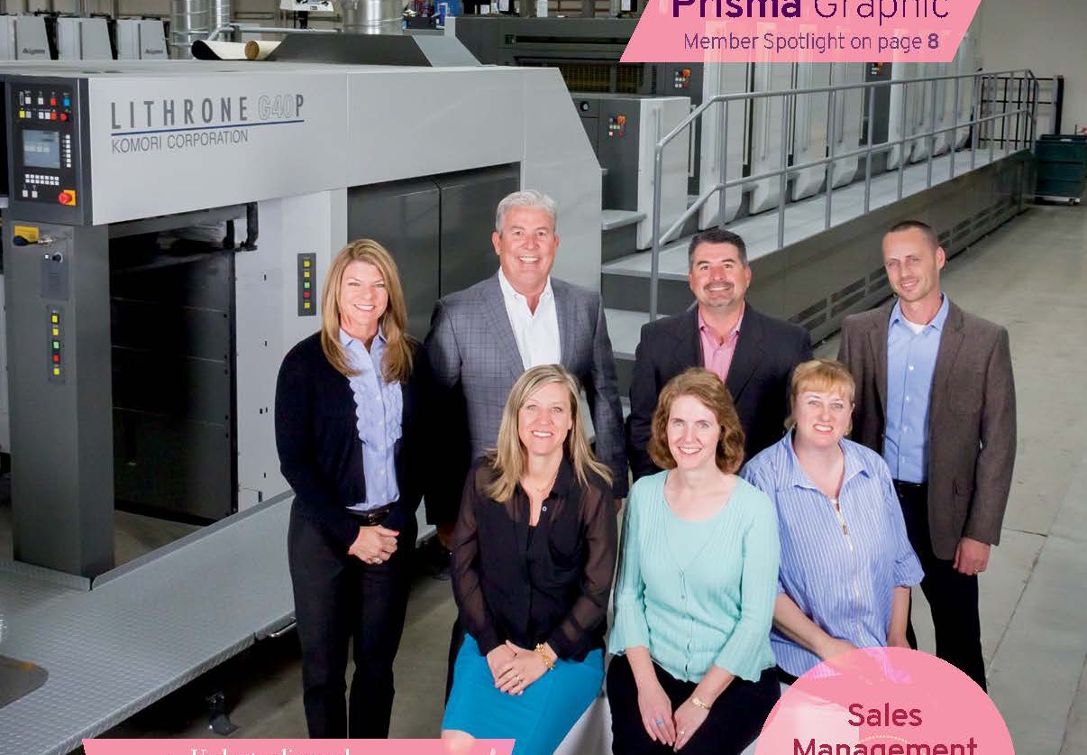 Prisma team standing by a press with a magazine cover feature reading Prisma