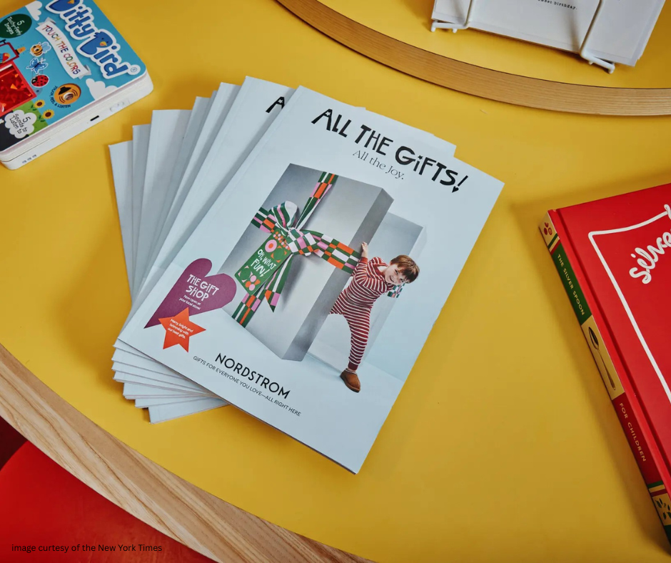 Nordstrom's "All the Gifts!" holiday catalog displayed on a table with other books.