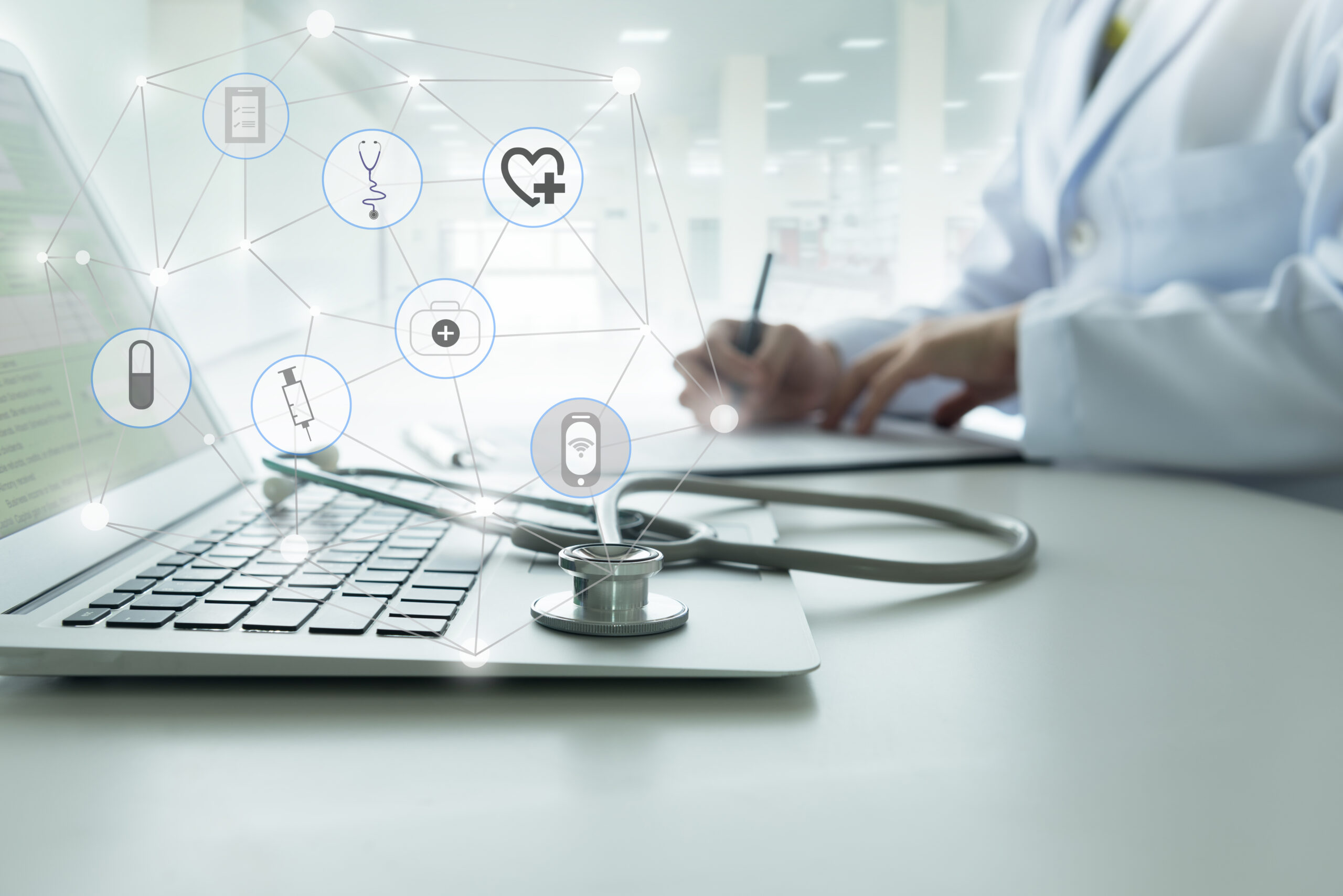 Doctor at a laptop with holographic healthcare icons and a stethoscope, symbolizing digital health tech.